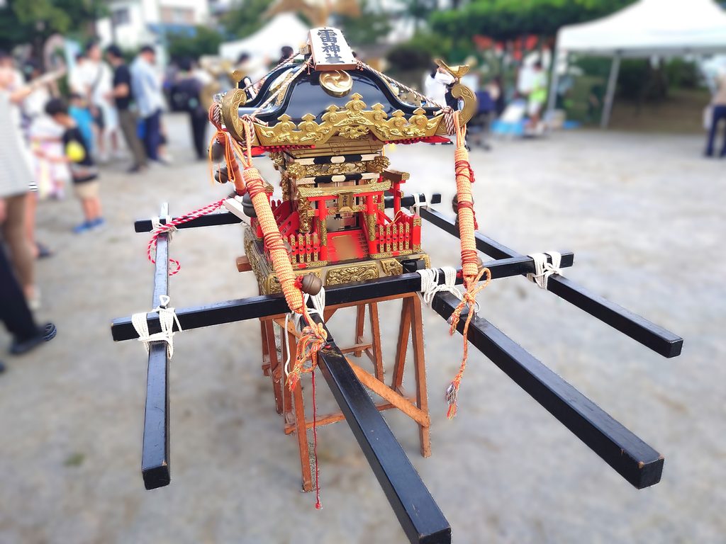 鰭ヶ崎自治会 夏まつりで展示されていた雷（いかづち）神社のお神輿。黒と金を基調とした装飾が施された立派なお神輿が置かれている。
